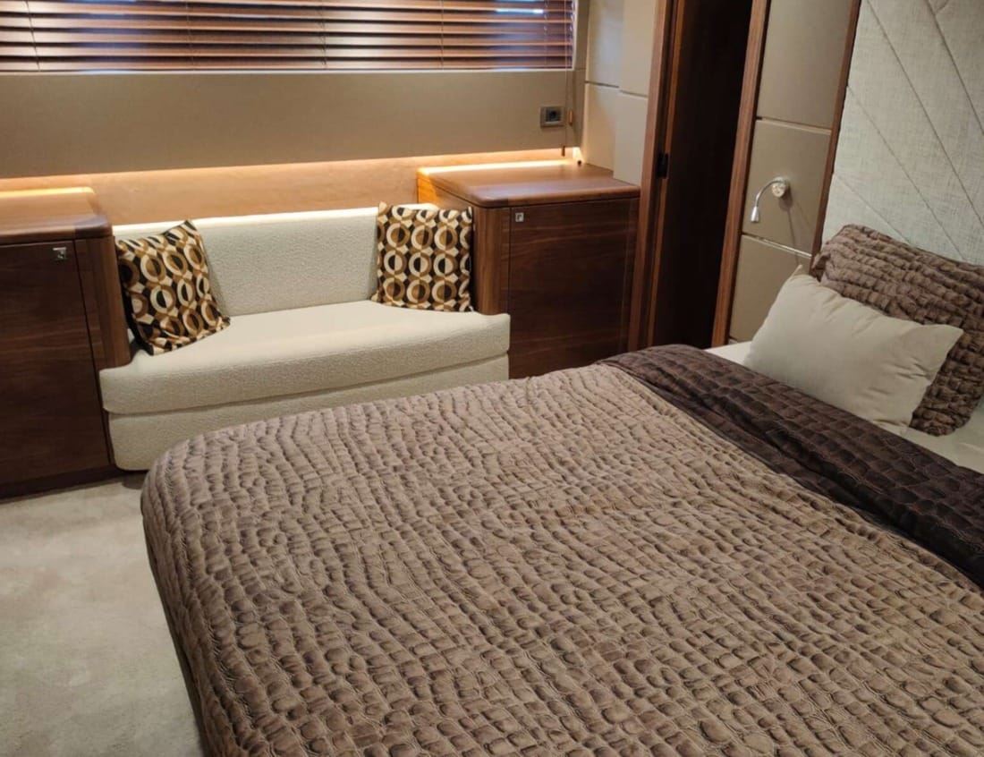 Bedroom of an Exclusive Deluxe 2000 Sportbridge - Exclusive Series yacht with double bed and seating area.