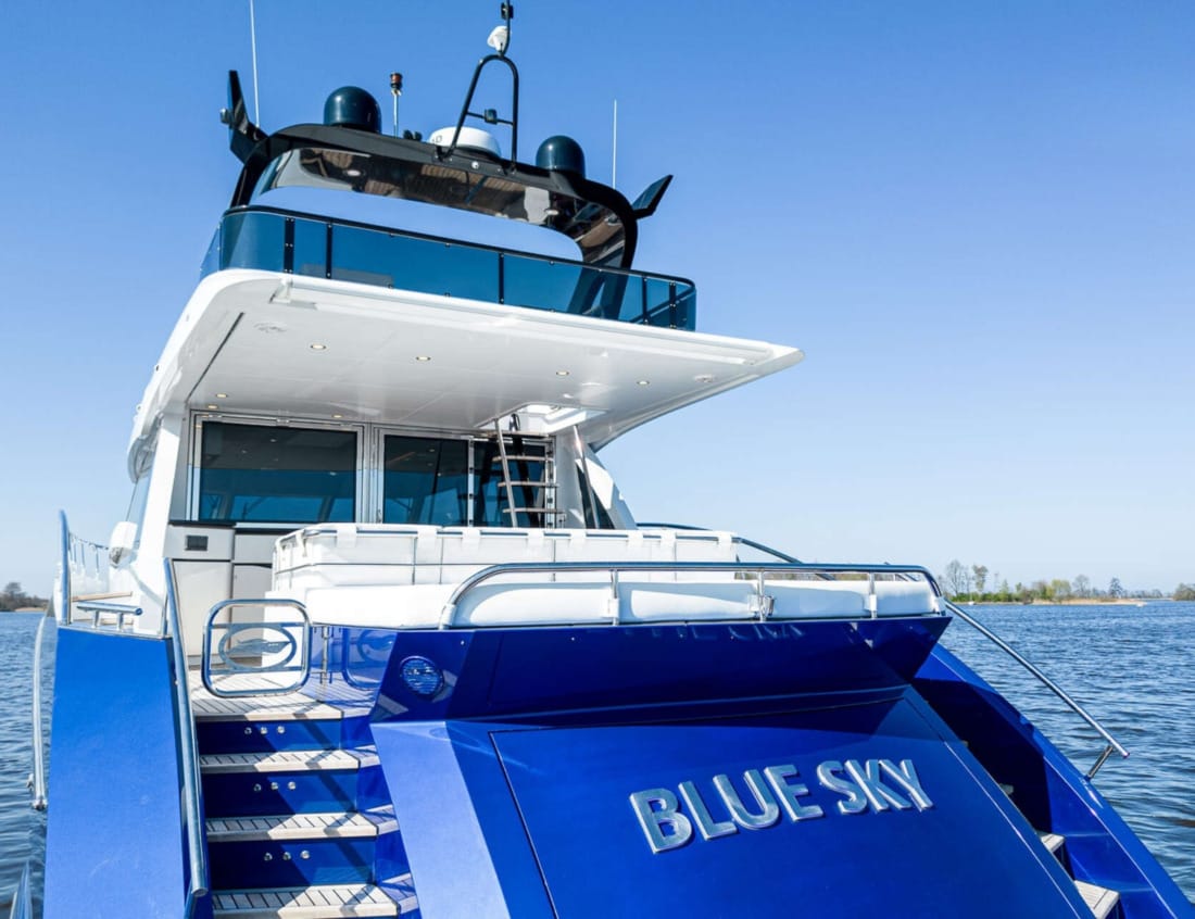 Rear view of a blue Phantom 70 yacht with flybridge and aft deck seating.