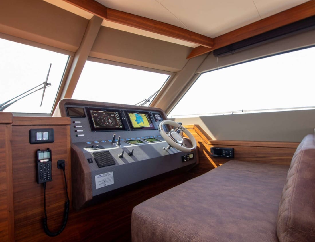 Helm station of an Exclusive Deluxe 1700 - Exclusive Series with steering wheel and navigation screens.