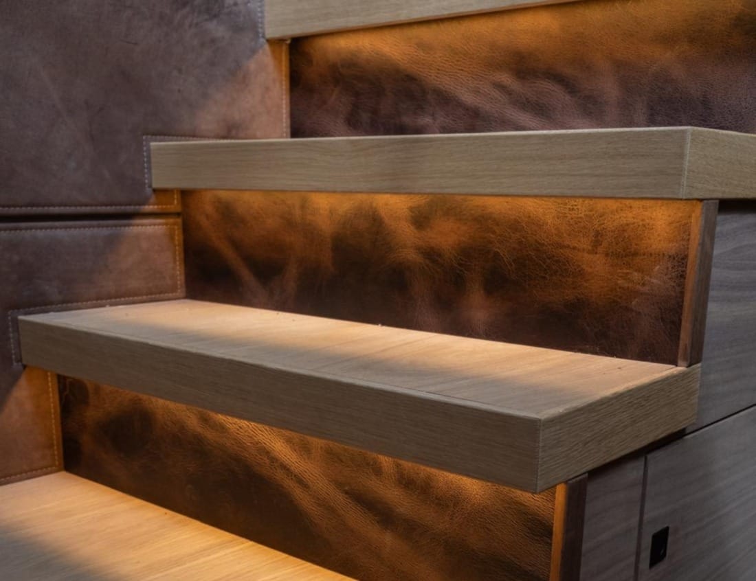 staircase of an Exclusive Deluxe 2000 Sportbridge yacht with wooden steps and leather panels.