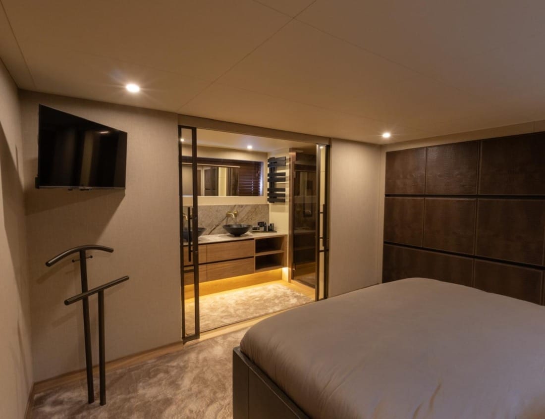Bedroom of an Exclusive Deluxe 2000 Sportbridge yacht - Exclusive Series with double bed and en-suite bathroom.