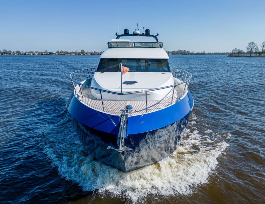 Aerial rear view of a blue Phantom 70 yacht on the water