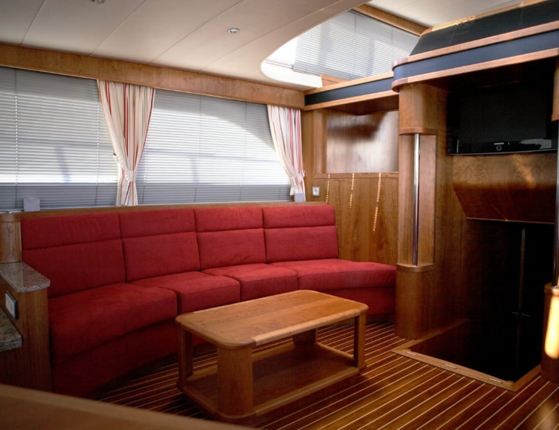 Interior of a Dynamic Deluxe 1800 - Dynamic Series with red lounge seating, coffee table and television.