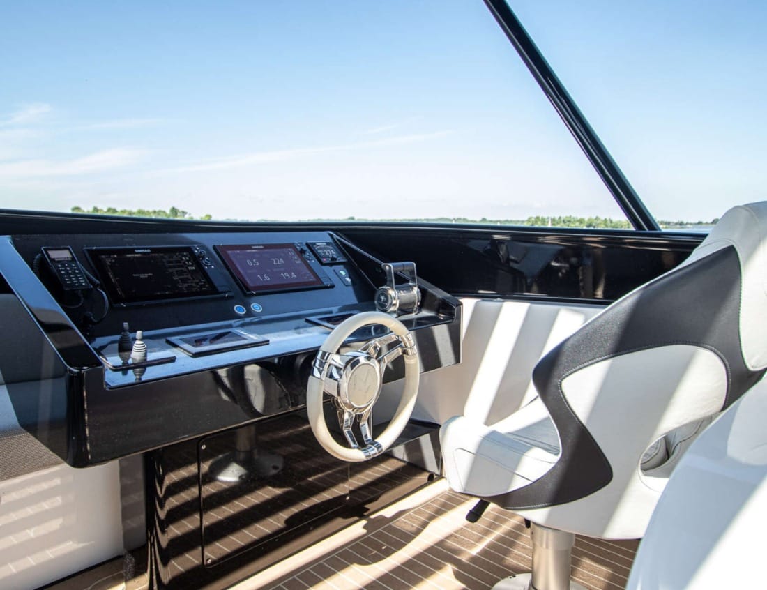 Helm station of a Phantom 80 Van der Heijden Yachts with steering wheel, navigation screens and captain’s chair.