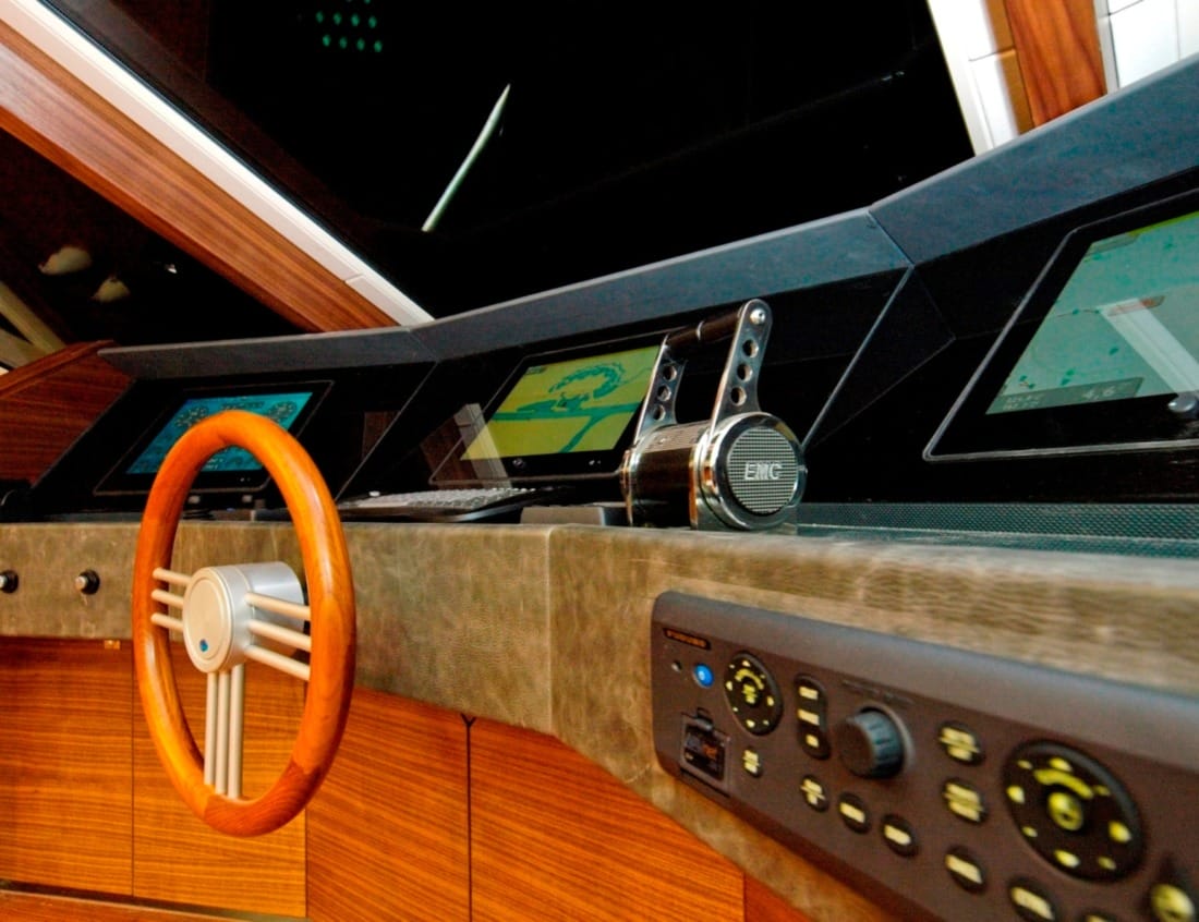 Helm station of a Superior 2400 Van der Heijden Yachts with wooden steering wheel and navigation screens