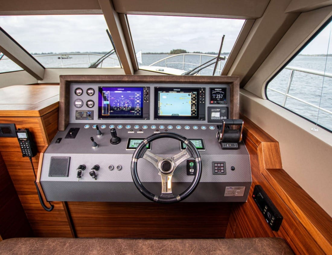 Helm station of an Exclusive Deluxe 1600 - Exclusive Series with steering wheel and navigation screens.