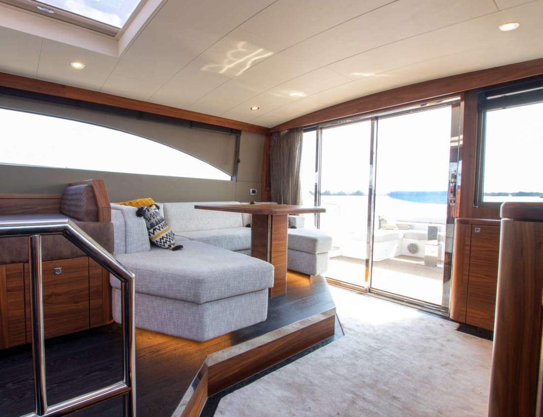 Interior of an Exclusive Deluxe 1700 - Exclusive Series with seating area, table and sliding doors to the aft deck.
