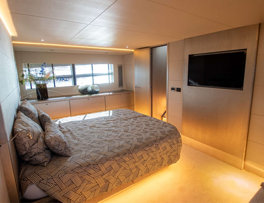 Bedroom of a Phantom 70 yacht with double bed and wall-mounted TV