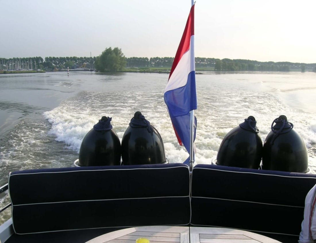 Dynamic Deluxe 1800 - Dynamic Series with Dutch flag, fenders and wake on the water.