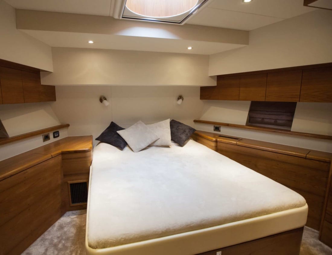 Bedroom of a Superior 2100 Van der Heijden Yachts with double bed and wood cabinets