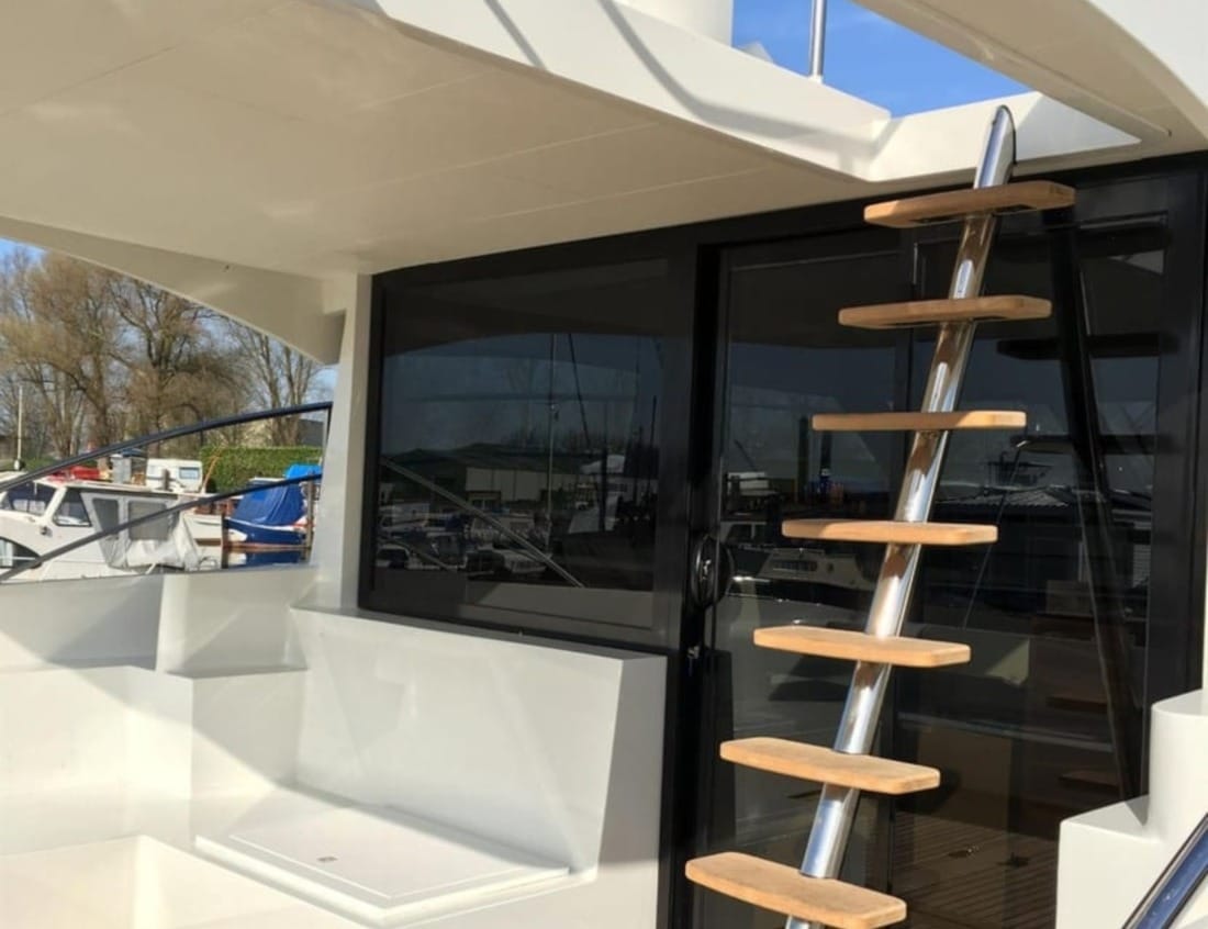 Aft deck of a Hayden Flybridge - Hayden Series with ladder to the flybridge and sliding glass doors.