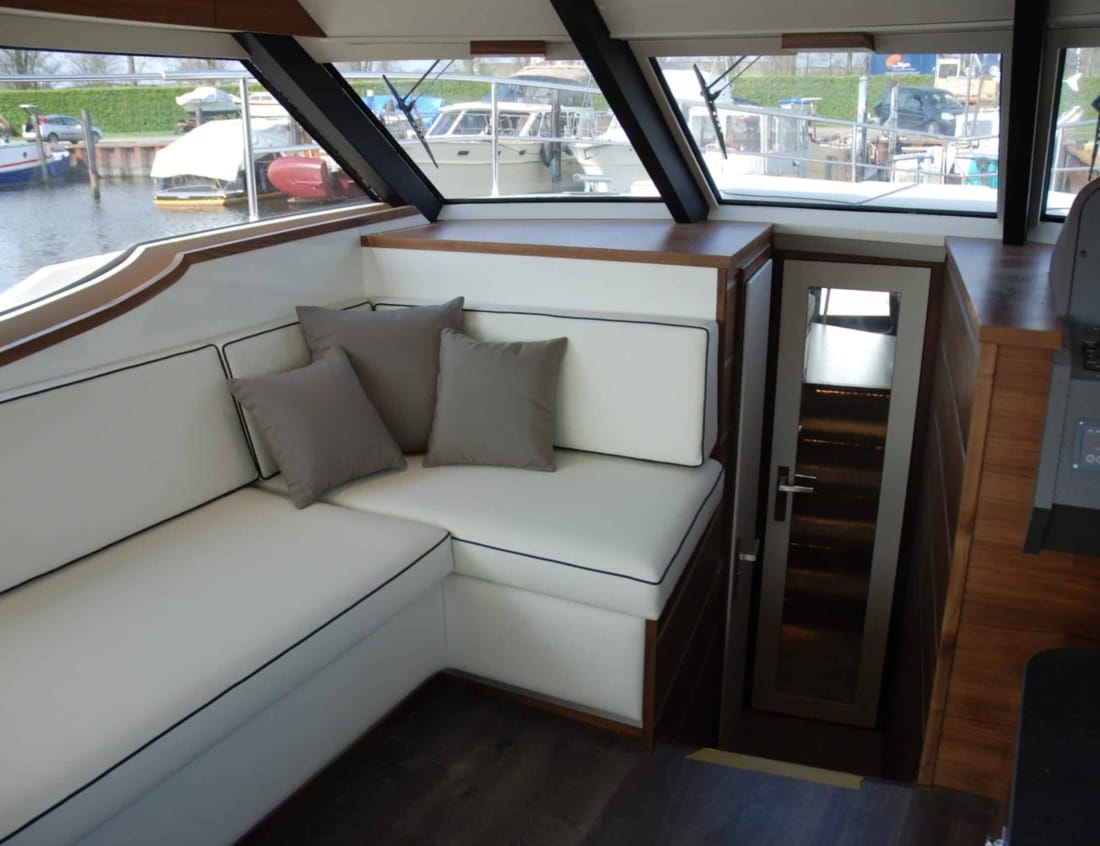 Interior lounge of a Hayden Flybridge - Hayden Series with white corner seating and stairway to the lower deck.