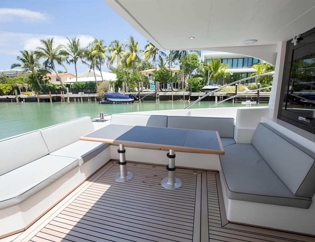 Aft deck of a Hayden Sedan - Hayden Series with wraparound seating, dining table and teak decking.