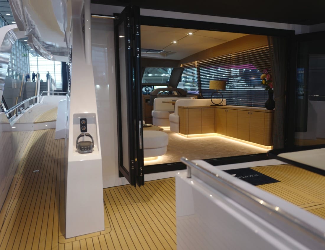 Aft deck of a Traveller 63 - Traveller Series with teak flooring and open access to the illuminated interior lounge.