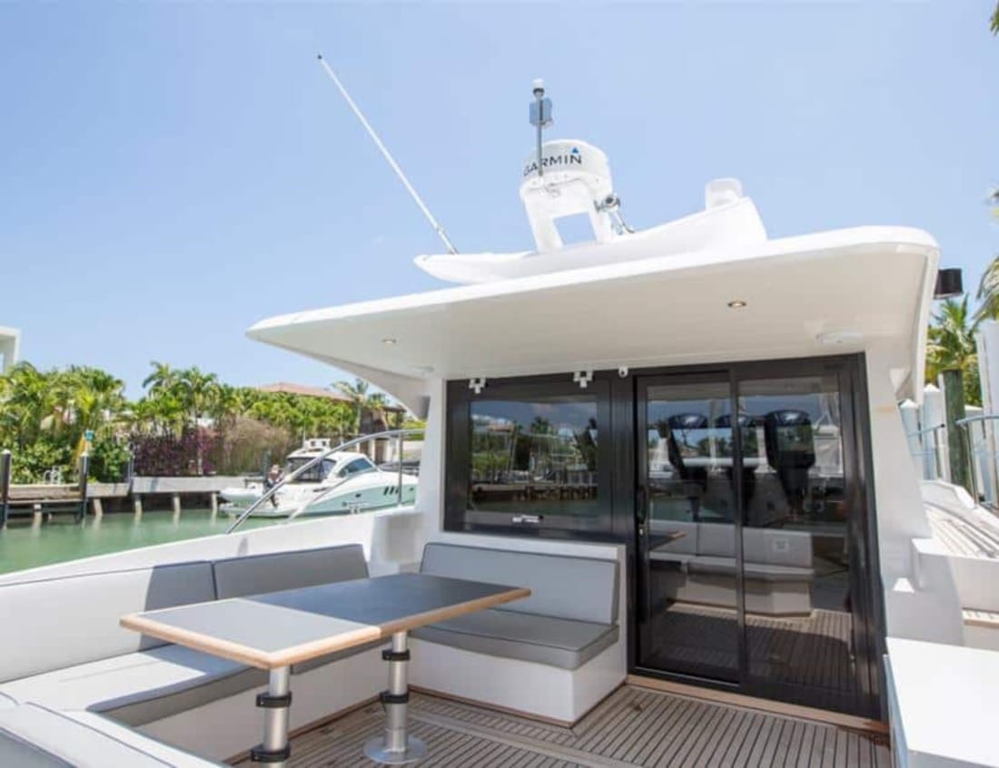 Aft deck of a Hayden Sedan - Hayden Series with seating, table and sliding glass doors.