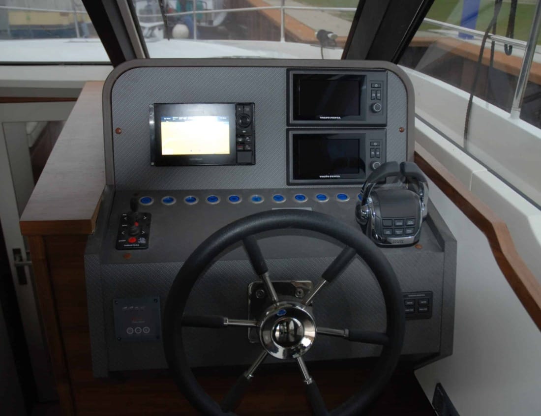 Helm station of a Hayden Flybridge - Hayden Series with steering wheel, navigation displays and throttle controls.